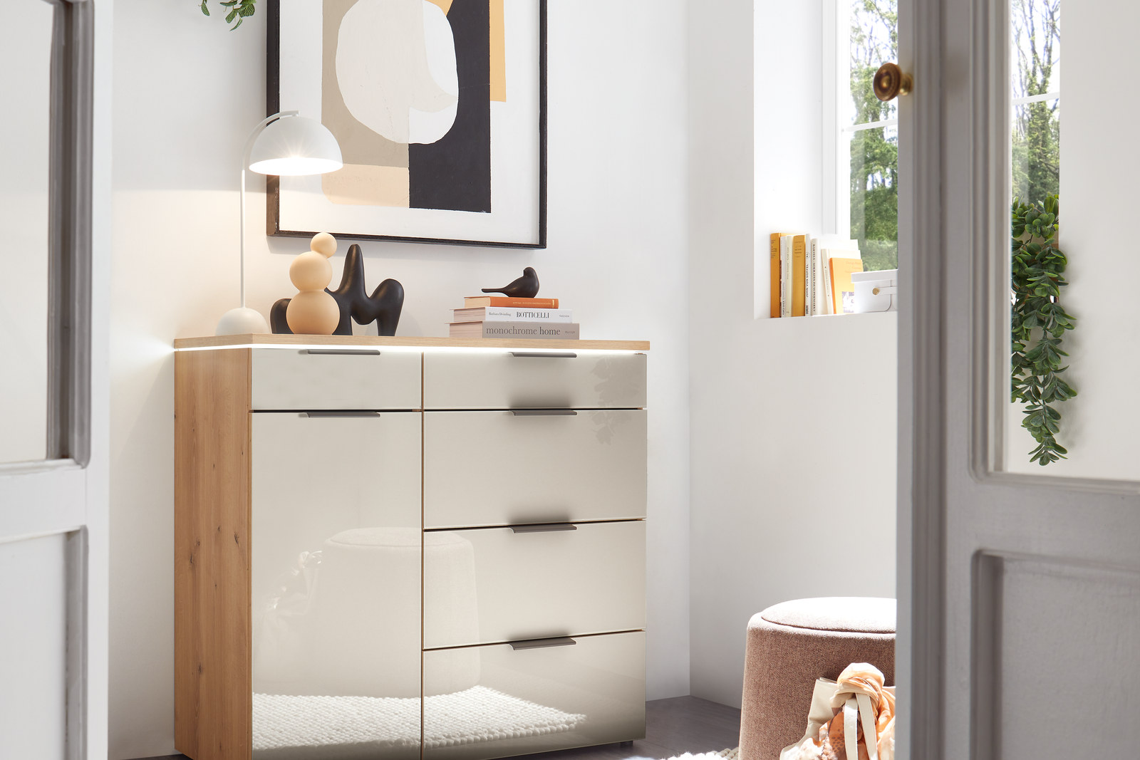 Kommode mit Eiche-Abdeckplatte, Glasfronten und Schubkästen in einem hellen Schlafzimmer